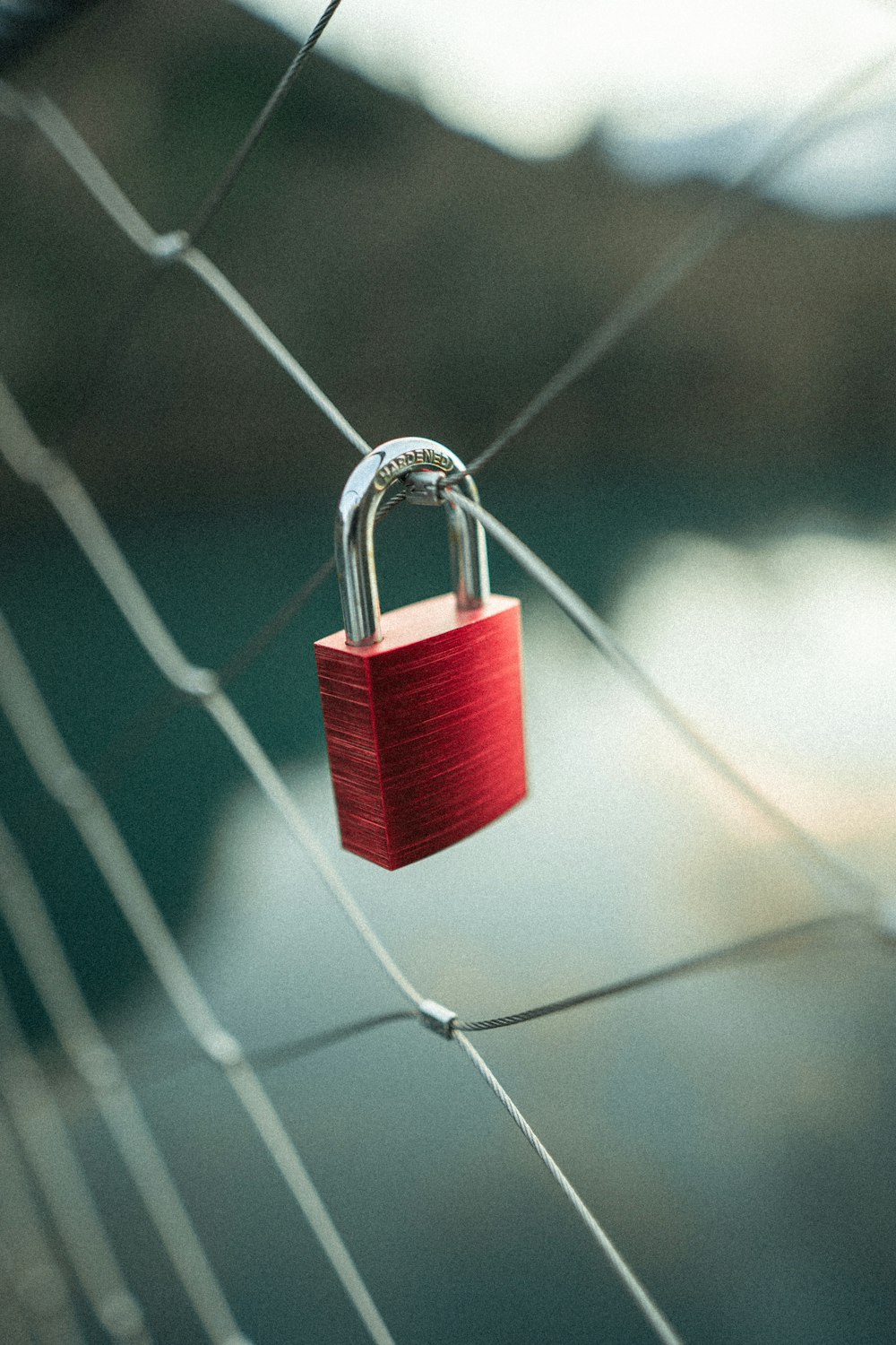 red padlock on gray wire fence