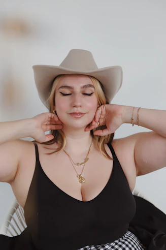 woman in black spaghetti strap top wearing white cowboy hat