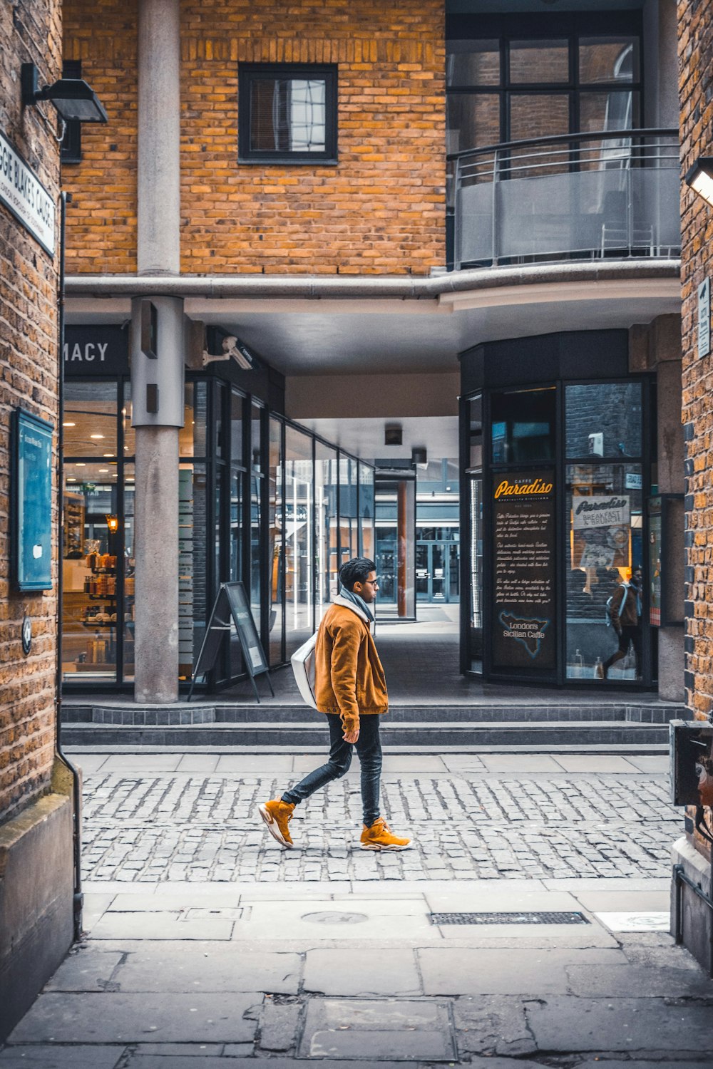 woman in yellow jacket and yellow pants walking on sidewalk during daytime