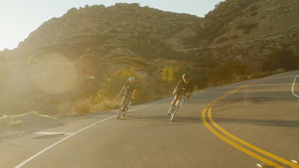 man in white shirt and black shorts riding bicycle on road during daytime