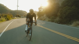 man in black t-shirt riding bicycle on road during daytime