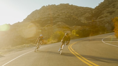 man in black jacket riding bicycle on road during daytime