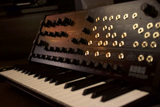 A vintage synthesizer with glowing knobs and colorful cables in a cozy studio.