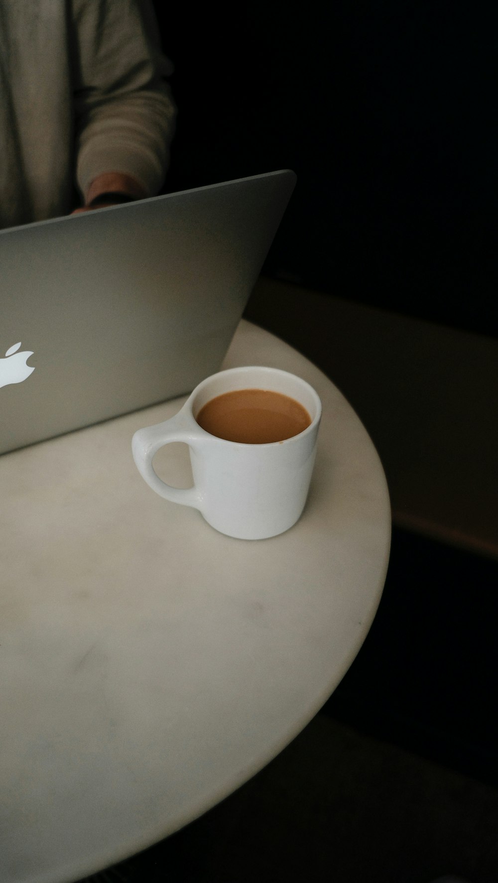 white ceramic mug on silver macbook