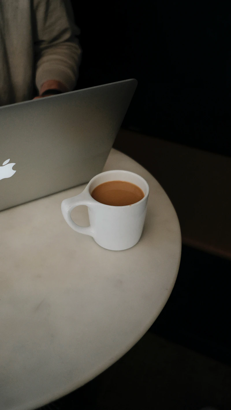 MacBook の上の白いマグ