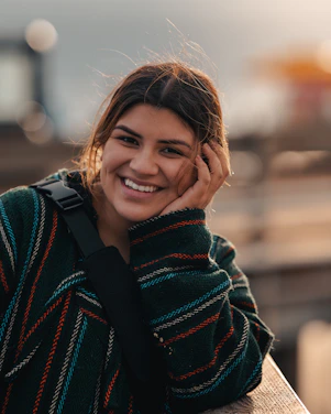 A warm, candid photo of 21nikoleta smiling, surrounded by colorful cardboard textures and playful icons.