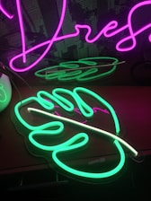 A vibrant workspace filled with mood boards, plants, and a glowing neon Wild Abandon sign.