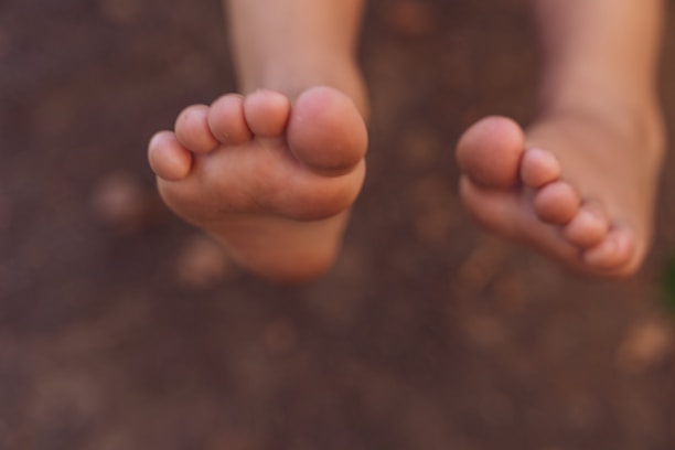 A close-up of a patient's feet being examined by a podiatrist.