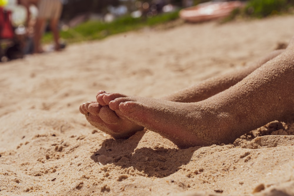 persons feet on brown sand during daytime