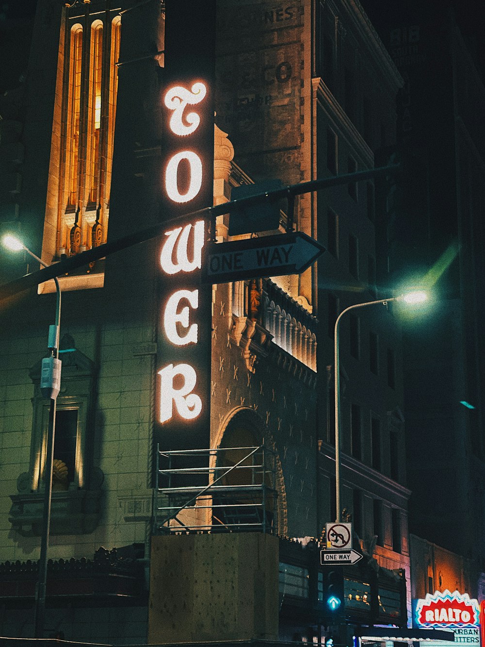 a tall building with a neon sign on the side of it