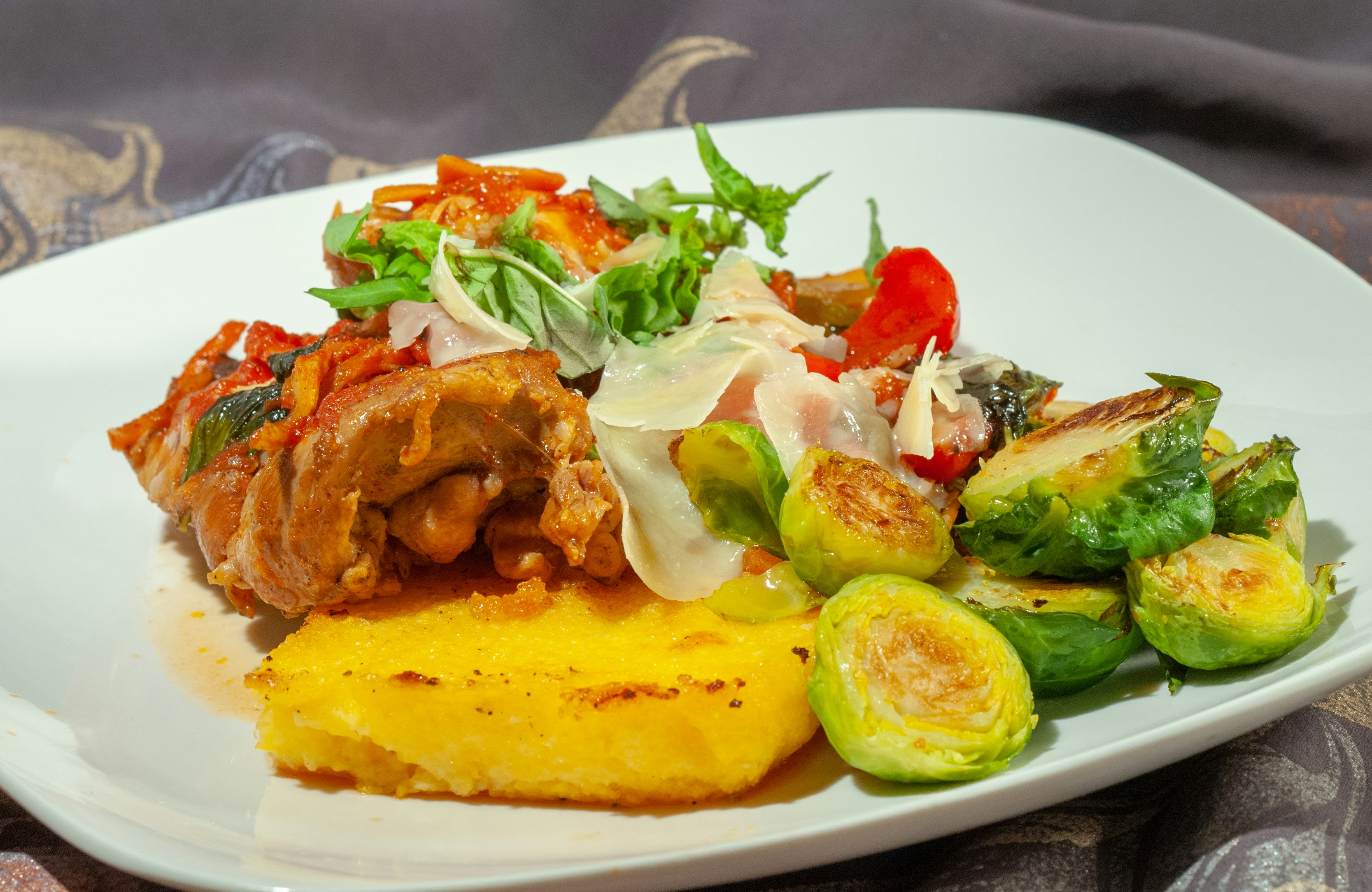 cooked food on white ceramic plate, Grilled Chicken Thigh on Grilled Polenta with salad and roasted Brussel Spourts