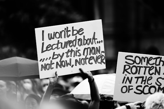 A cartoonish illustration of a frustrated group holding signs that say 'No Ian!'