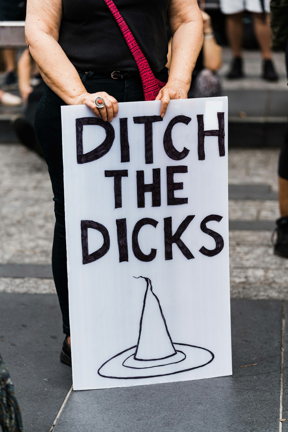 person holding white and black wooden signage