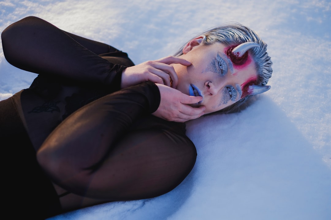 man in black shirt lying on blue textile