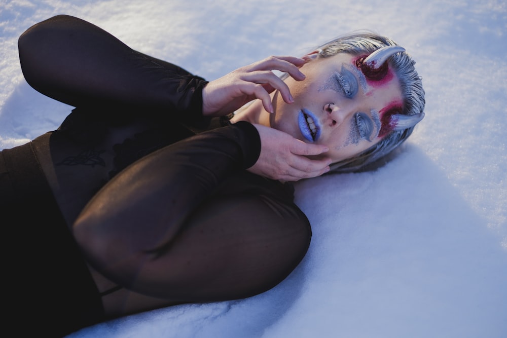 femme en débardeur noir allongée sur textile bleu