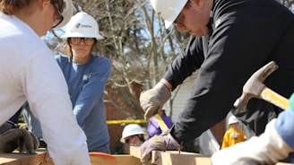 man in black jacket and white hard hat holding green plastic bottle