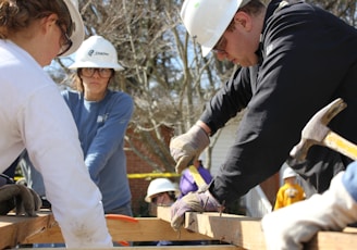 man in black jacket and white hard hat holding green plastic bottle