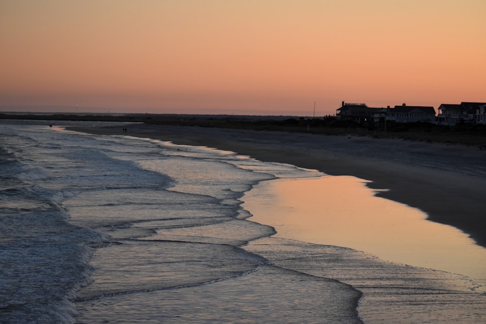 silhouette of building on beach during sunset