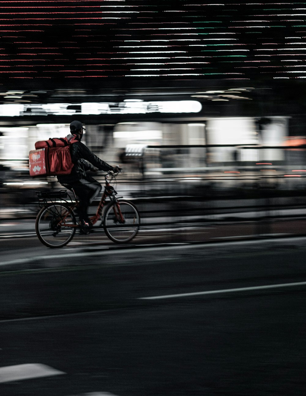 街で自転車に乗る赤いジャケットの男