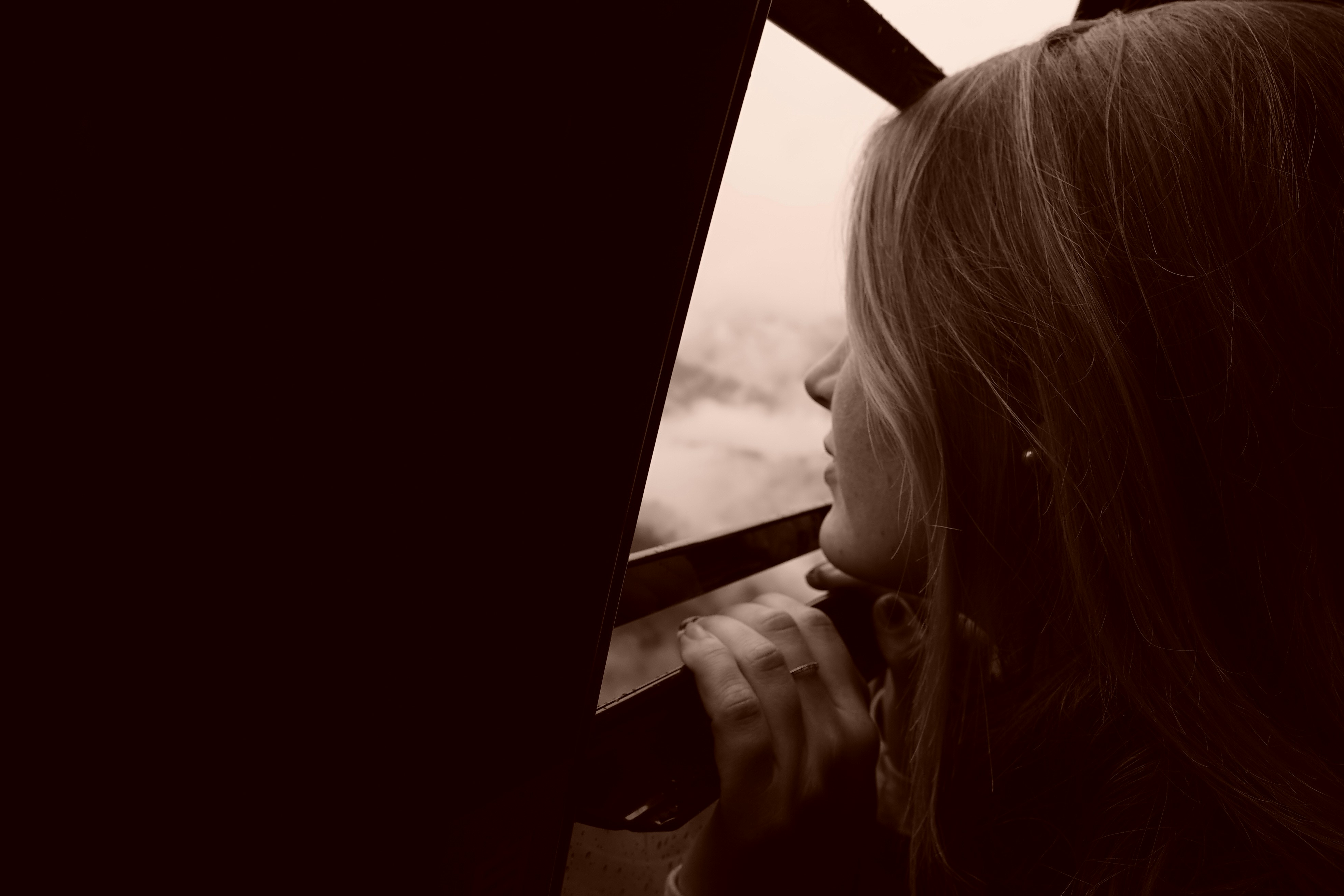 mulher que se apoia na cerca de madeira marrom durante o dia