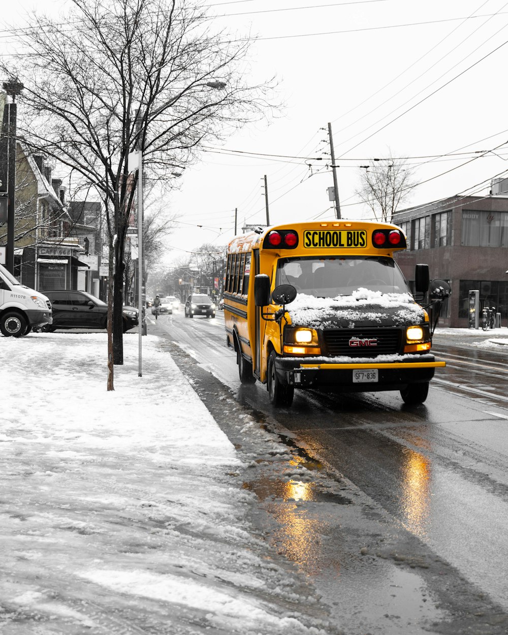 yellow school bus on snow covered road during daytime