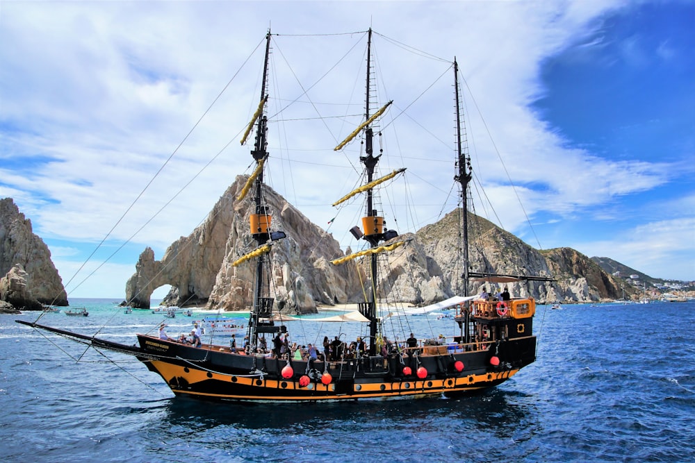 brown and black sail boat on body of water during daytime