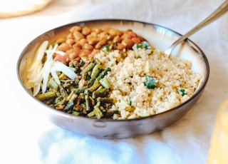 cooked rice with green peas and carrots on stainless steel bowl