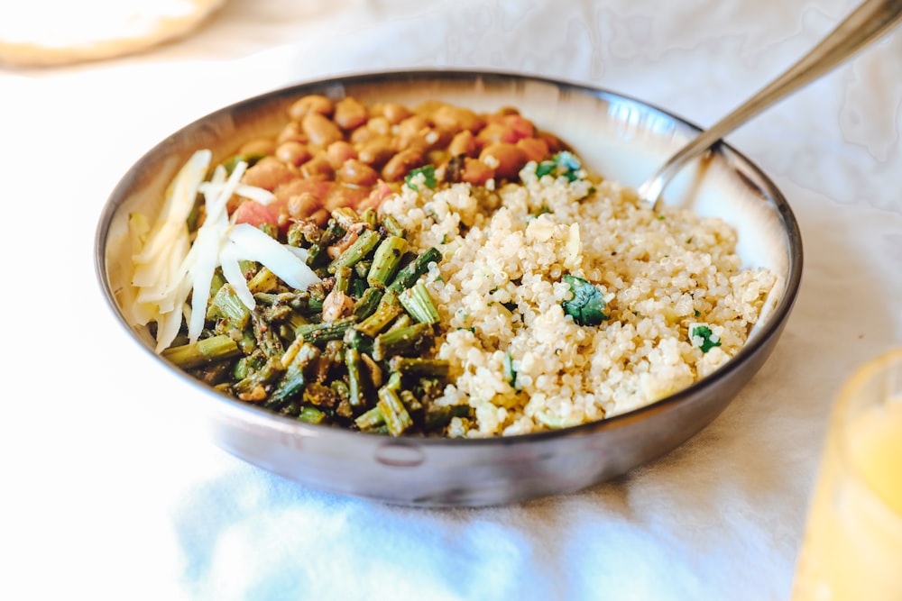 Arroz cocido con guisantes y zanahorias en un bol de acero inoxidable