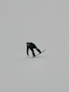 man in black jacket and pants standing on snow covered ground