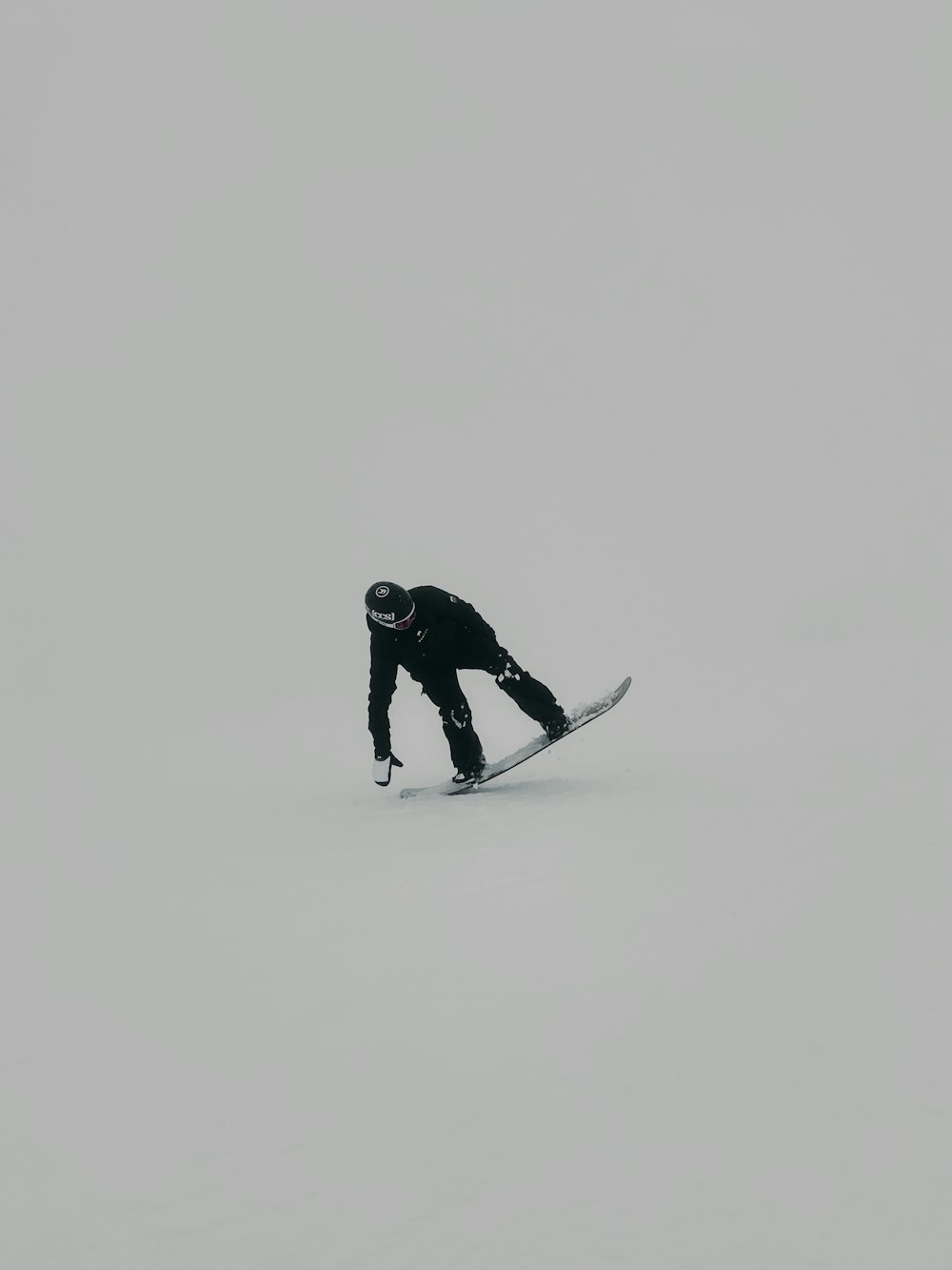 man in black jacket and pants standing on snow covered ground