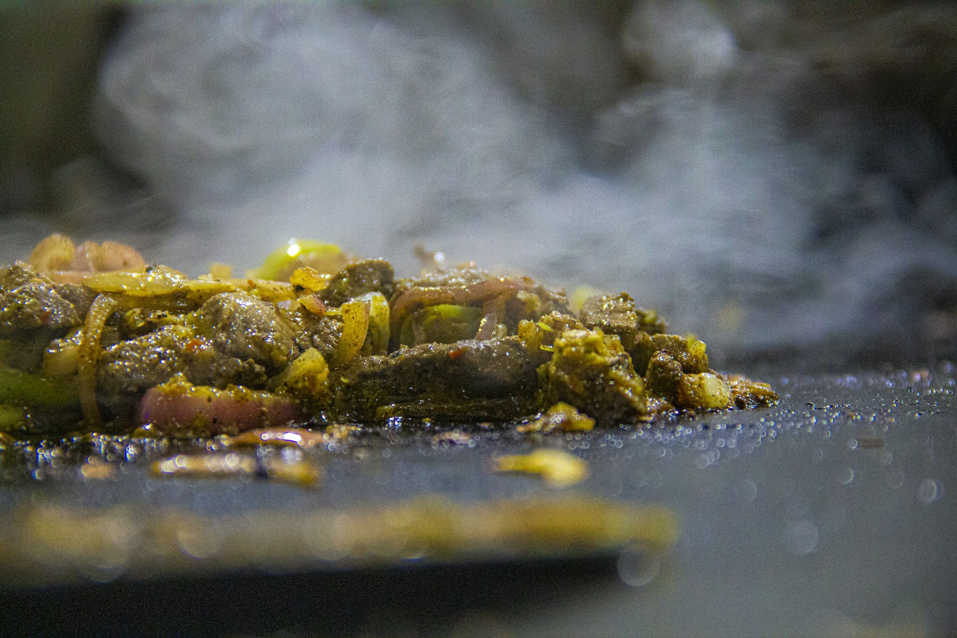 A close-up shot of a sizzling pan with colorful vegetables and herbs cooking, steam rising gently.