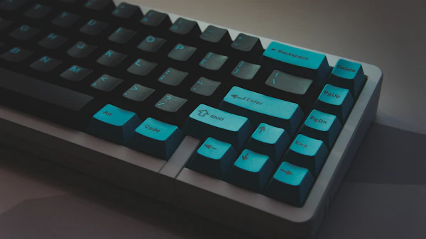 Dark mechanical keyboard with cyan accent keycaps close-up