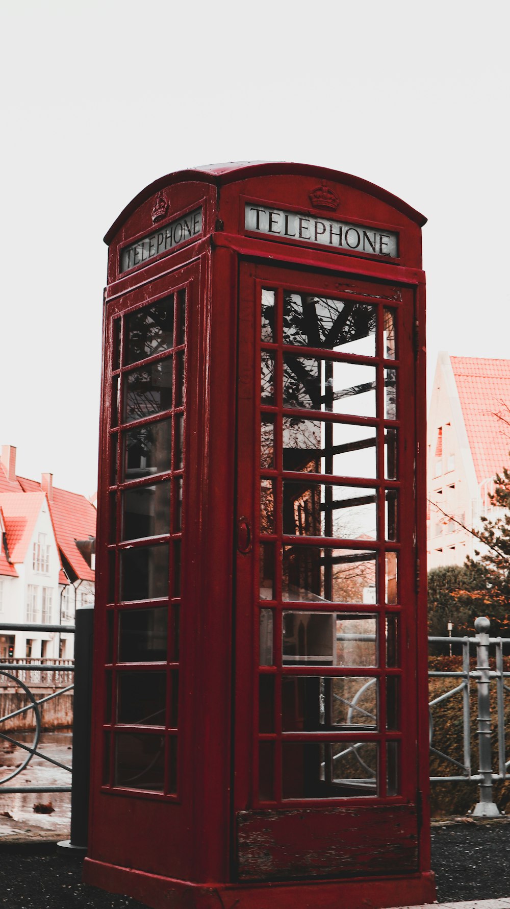 red telephone booth near brown concrete building during daytime