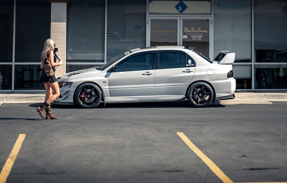 white sedan parked beside white building