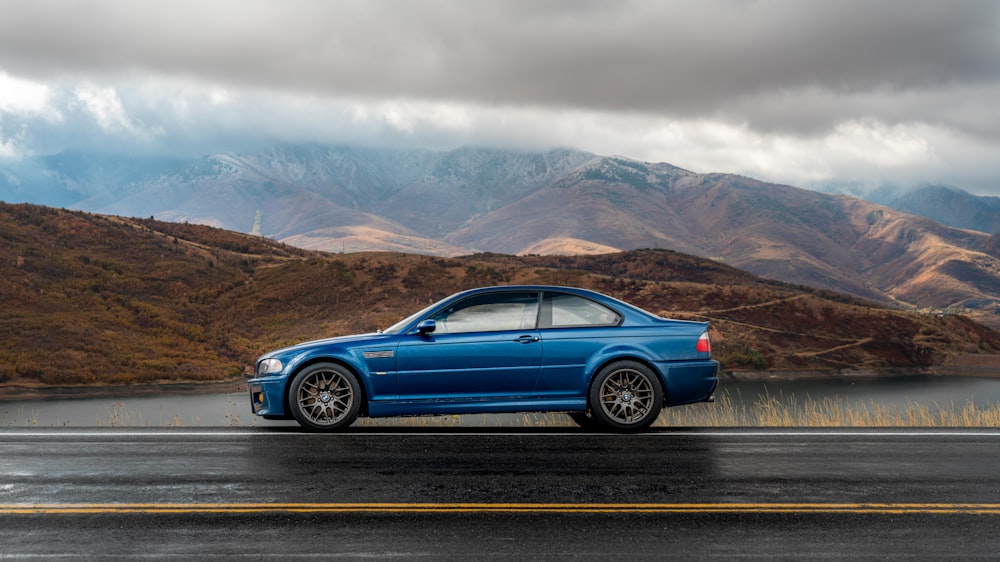 blue sedan on gray asphalt road during daytime