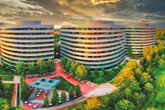 high rise building near green trees under white clouds during daytime