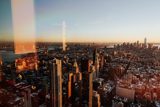 A sharp digital image of a bustling city corner bathed in late afternoon light.
