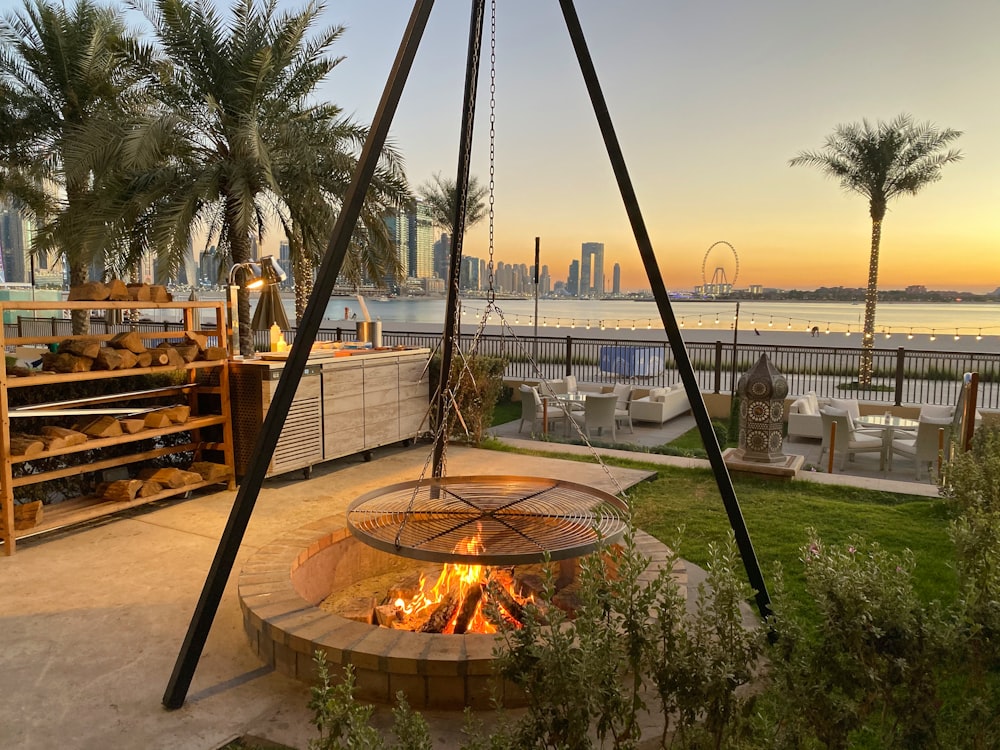 brown round fire pit with green palm trees during daytime