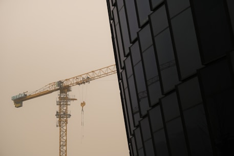 yellow crane near black building
