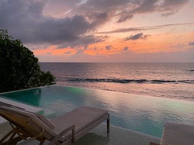 white wooden table and chairs near body of water during daytime