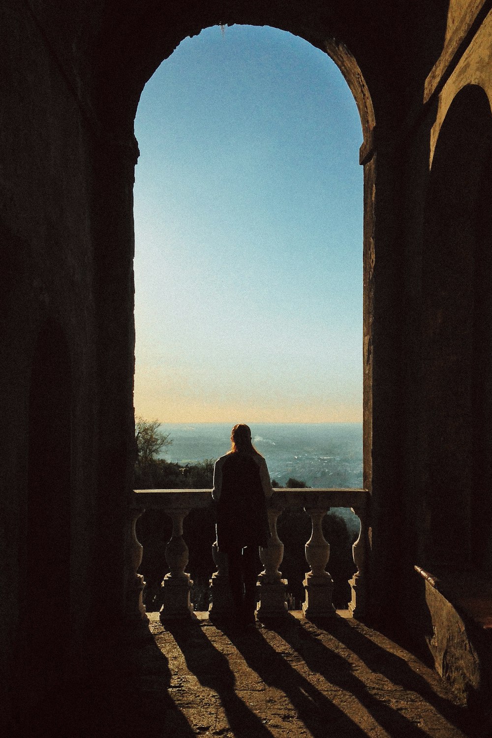 silhouette of people standing on balcony during sunset