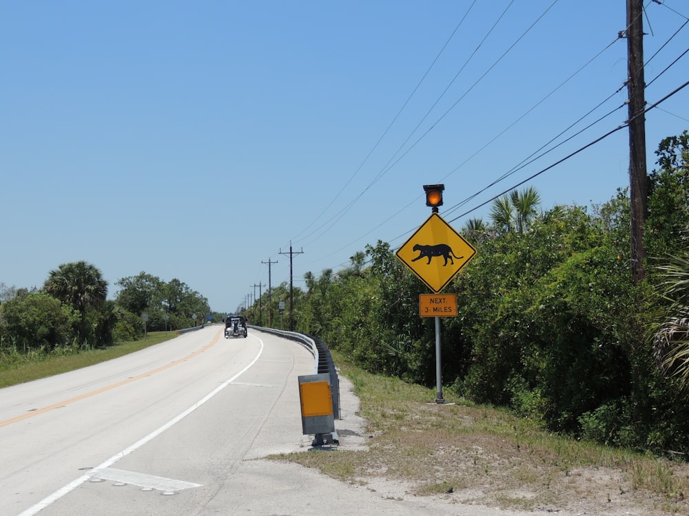 yellow and black stop sign on gray asphalt road during daytime