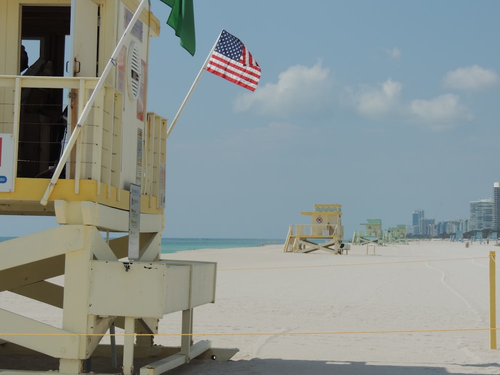 white and yellow wooden building on white sand during daytime