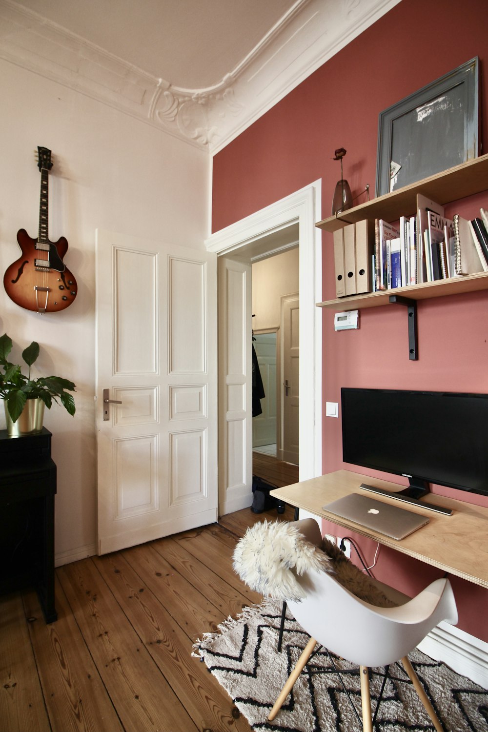 brown acoustic guitar on white wall