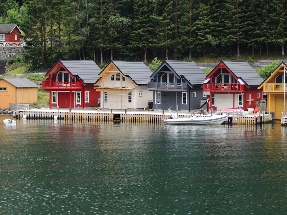 white and red house beside body of water during daytime