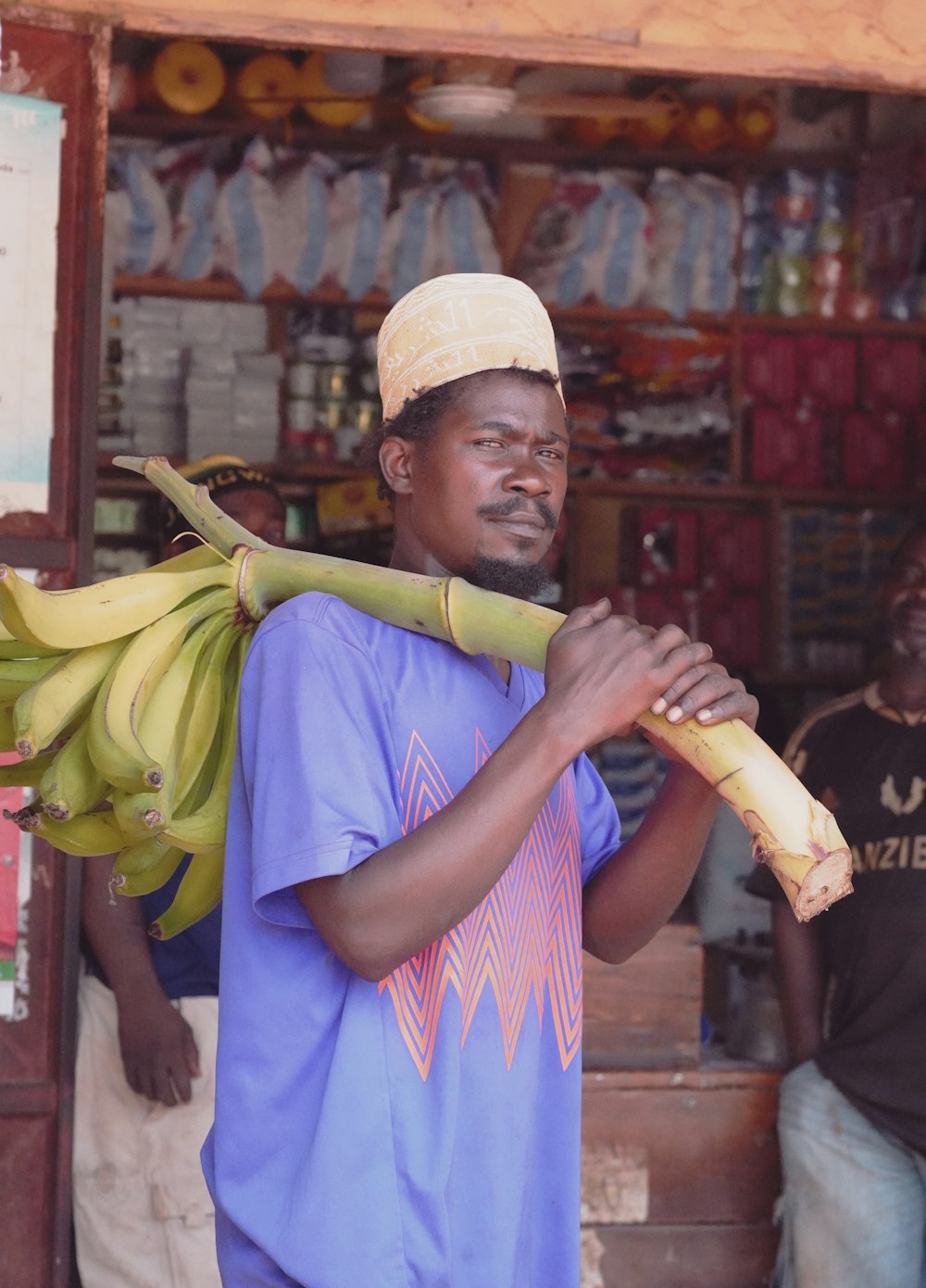 man in blue shirt holding banana