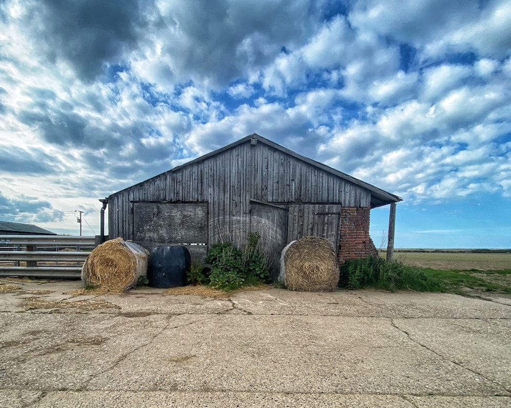 brown wooden barn under blue sky and white clouds during daytime