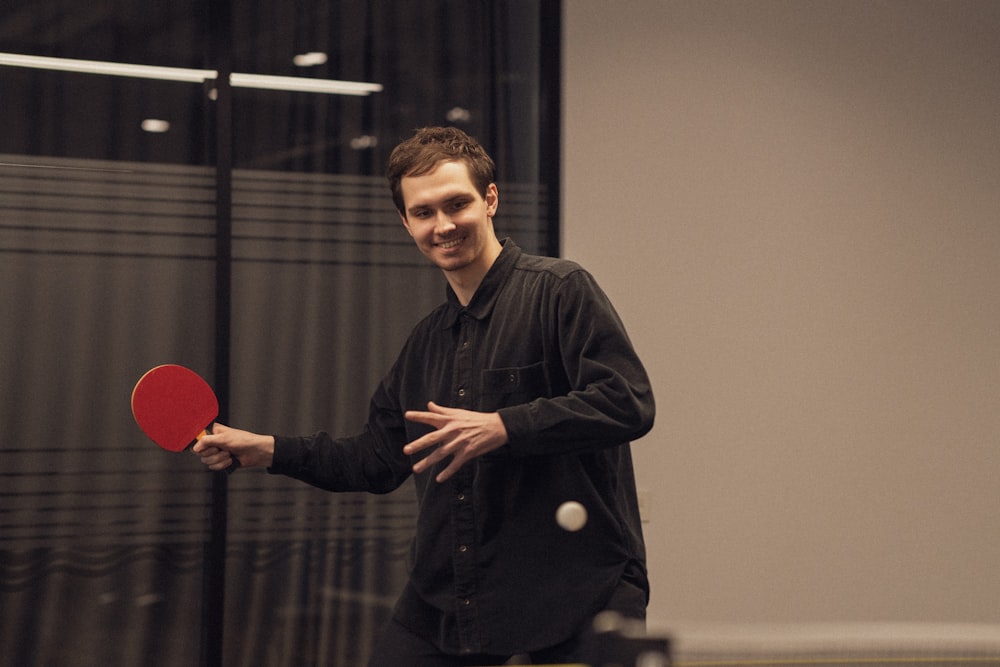 man in black long sleeve shirt holding red heart