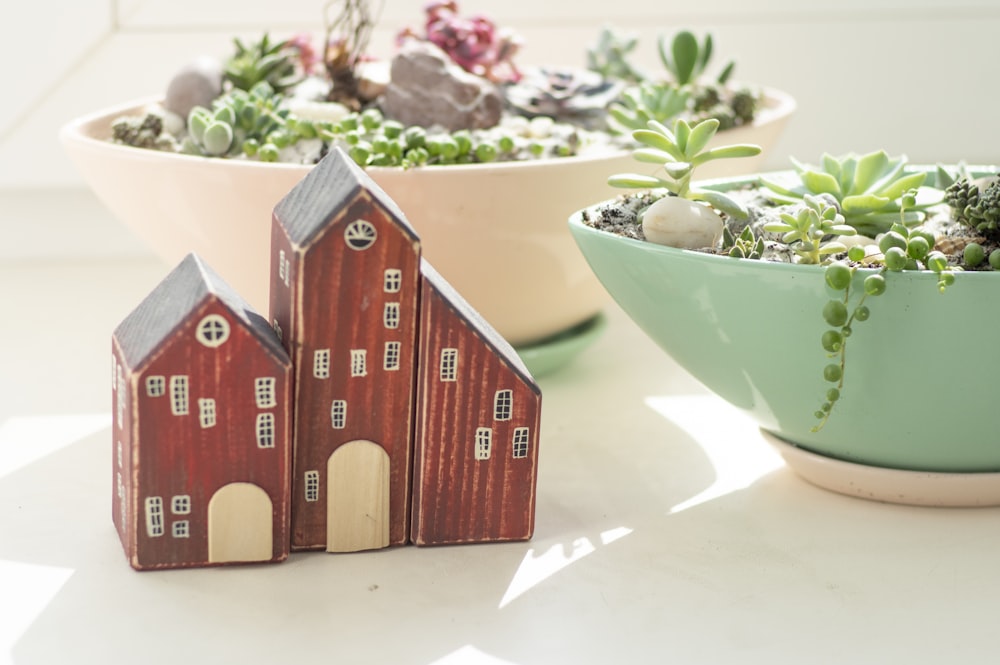 Miniatura de la casa de madera marrón sobre mesa blanca