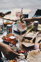 person holding blue can and drinking glass